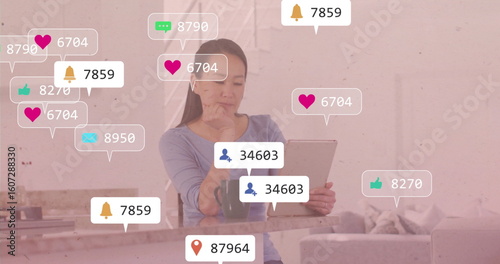 Korean woman holding tablet and contemplating at kitchen peninsula, with mug and notification icons