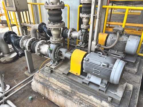 industrial zone steel pipes. Heavy-duty industrial pumps with electric motors and extensive piping, crucial for fluid management in a modern factory or plant 