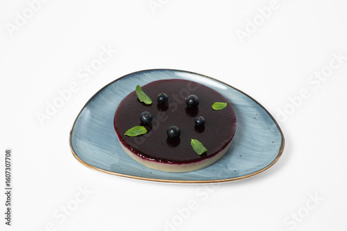 Pelamushi, low-calorie blackcurrant mousse cake on a plate on a white background
