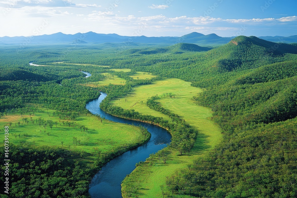 Obraz premium Lush green valley with winding river, mountains in the background. A vista of a serene landscape