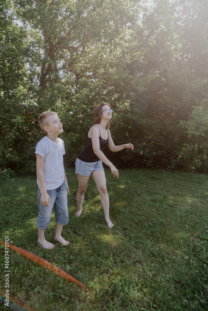 Obraz premium A mother and her son with hearing aids launch a paper airplane in a park, a heartwarming moment of inclusive play and bonding in nature. Perfect for disability awareness and family lifestyle content
