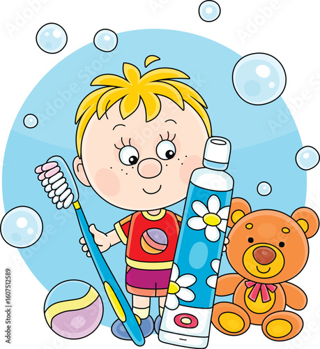 Little boy with his toys holding a toothbrush and toothpaste for teeth cleaning, ready for morning and evening everyday oral hygiene, vector cartoon illustration on a white background