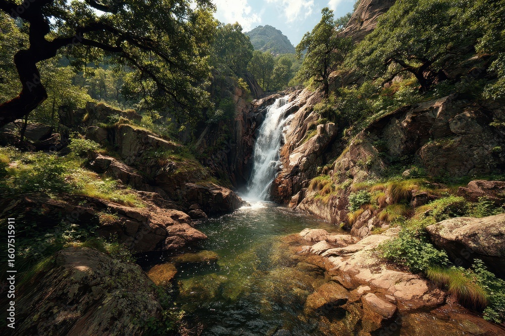 Fototapeta premium Breathtaking waterfall cascading down rocky cliffs surrounded by lush greenery in a serene mountain setting during daylight hours