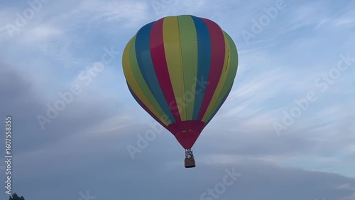 Colorful hot air balloon soaring in the blue sky during a calm day


