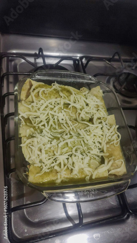 Vertical photo of delicious green chicken enchiladas with cheese.