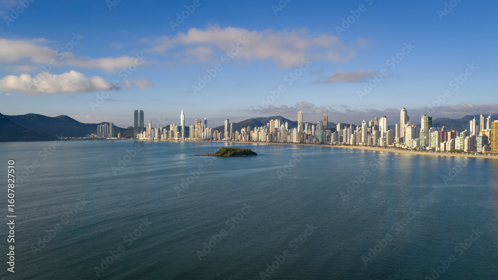 Naklejka premium Morning aerial view of Balneário Camboriú skyline and beach with calm ocean and blue sky.