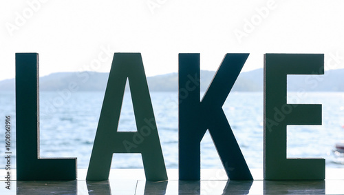 Standout letters spell the word LAKE in front of Lake Couer D' Alene in Idaho. 