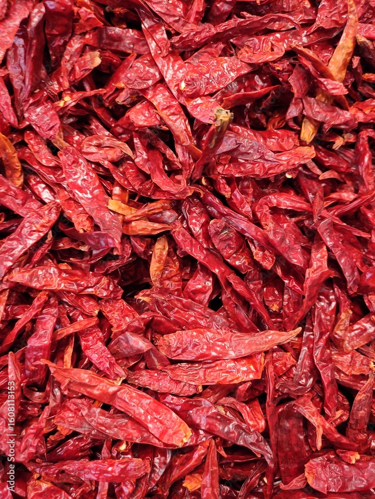 Fototapeta premium Close-up of a pile of air-dried red chilies. Hot and spicy dried red chilies.Primer plano Montón de fondo de chiles rojos secados al aire. Chiles rojos secos calientes y picantes.(16)