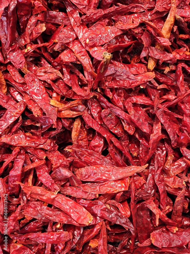 Fototapeta premium Close-up of a pile of air-dried red chilies. Hot and spicy dried red chilies.Primer plano Montón de fondo de chiles rojos secados al aire. Chiles rojos secos calientes y picantes.(17) 