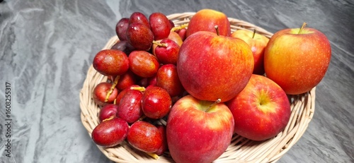 Red fruits in a white wooden basket on a marble table.