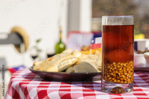 Chilean Independence Day traditional drink mote con huesillo and empanadas on a table