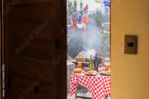 Chilean Independence Day: barbecue scene viewed from doorway with decorated table