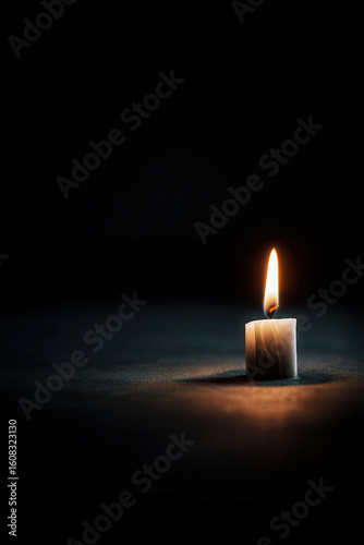 tribute to victims of terrorism featuring ultrabright candle gently flickering against clean background