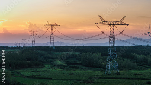High-voltage transmission towers under the sunset in the countryside
