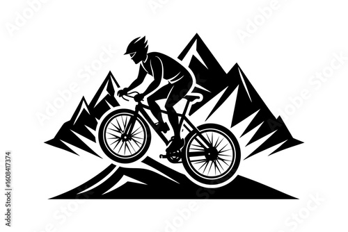 Silhouette of a mountain biker riding downhill with mountains behind