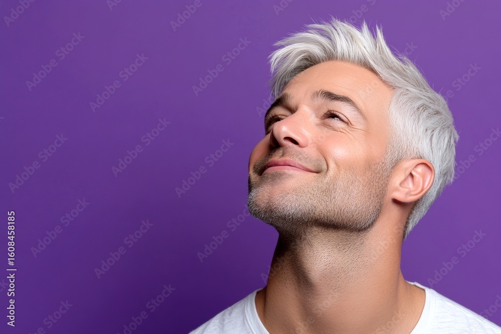 Obraz premium Trendy men's ivy league haircut - midlife white man with white hair. Purple solid background. A happy and poised man radiating charm. Visual idea of style for aging men.
