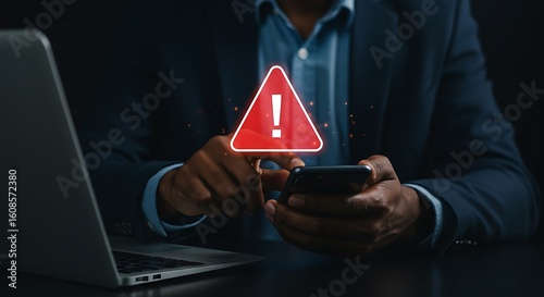 Businessman receives mobile phone notification displaying red alert warning sign for cyber security