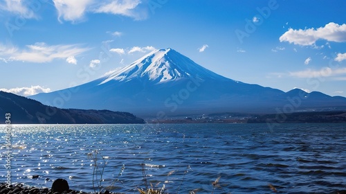 Iconic view of Mount Fuji, Japan's highest peak with a snow-capped conical summit, surrounded by cherry blossoms in spring, vibrant autumn foliage, and the serene waters of Lake Kawaguchi reflecting i