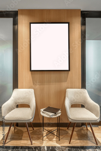 Blank vertical frame mockup in a modern waiting area with two beige chairs and a wood panel wall. Ideal for displaying art or posters.