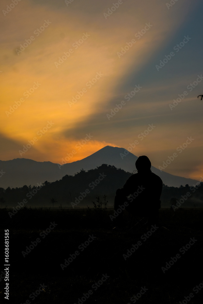Fototapeta premium Contemplative silhouette against mountain dawn