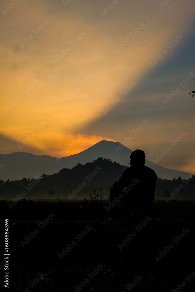 Fototapeta premium Silhouette contemplates mountain sunset glow
