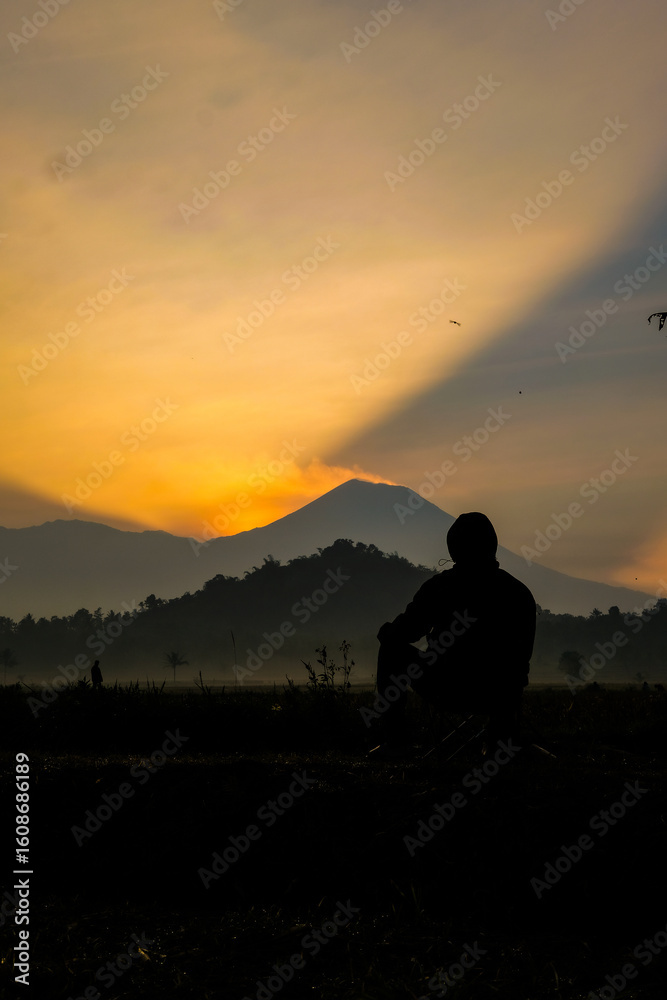 Fototapeta premium Silhouette gazing at sunrise mountain