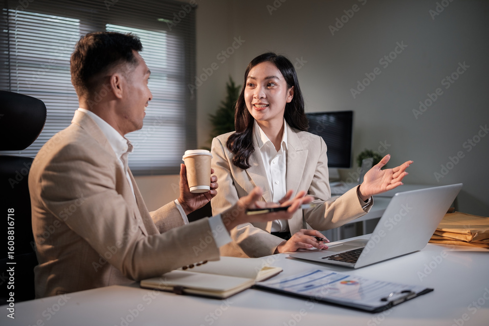 Obraz premium Professional man and woman talking during a brainstorming session in a corporate workspace.