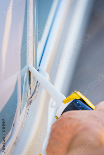 Applying silicon on caravan body