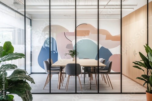 A modern glass office meeting room with abstract wall art and Scandinavian-style furniture, featuring clean lines and lush greenery.