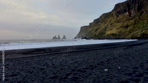 Dramatic cinematic view of the famous Black Sand Beach seen from the town of Vic in Iceland , Destination of travel landmark of Iceland.