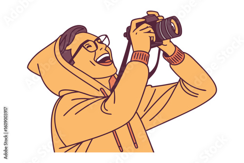 Joyful person with glasses captures a moment with a dslr camera wearing a hooded sweatshirt