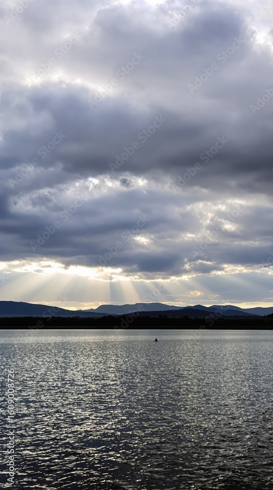 Obraz premium Dramatic Sky and Lake with Mountain Silhouette