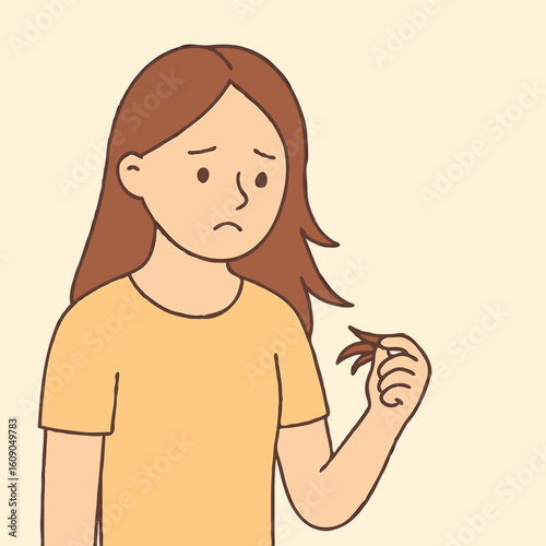 Young woman looking worried while holding a strand of hair  