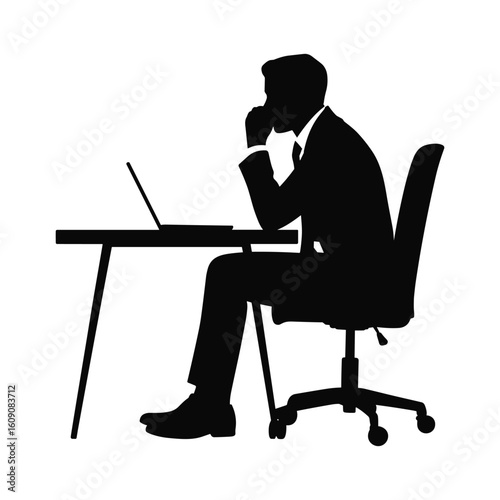 Silhouette of a businessman thinking deeply at his desk with a laptop