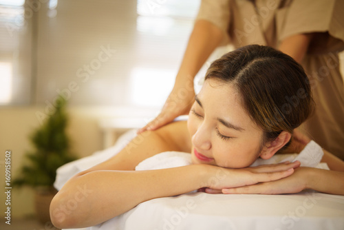 Young woman enjoying a relaxing massage therapy session at a luxury spa. Health and wellness concept.
