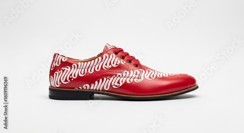 Model wearing red batik sneakers with white soles. Fashion-forward take on Indonesian traditional textile applied to contemporary streetwear.