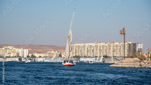 Принти на полотні A traditional felucca sails the clear, blue waters of the Nile River near Aswan,