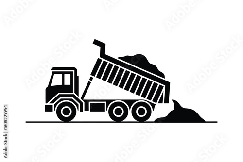 Silhouette of a dump truck unloading dirt and gravel