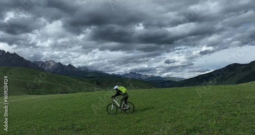 Aerial footage of riding mountain bike in the beautiful flowering grassland and forest mountains