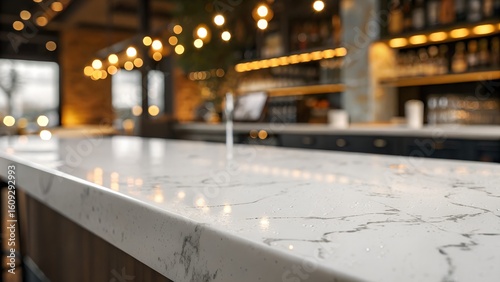 A smooth white marble bar counter glows under warm string lights in a softly blurred restaurant interior.
