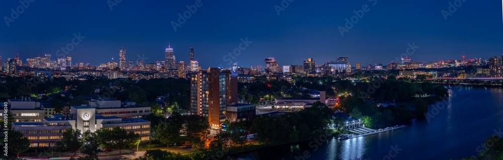 Obraz premium Boston skyline at night with river and buildings.