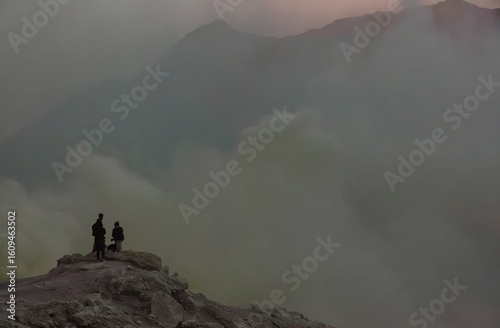 Sunrise image of tourists looking out over Kawah Ijen, a beautiful turquoise crater lake in the stratovolcano Mount Ijen, located in East Java, a province on Indonesia's Java island