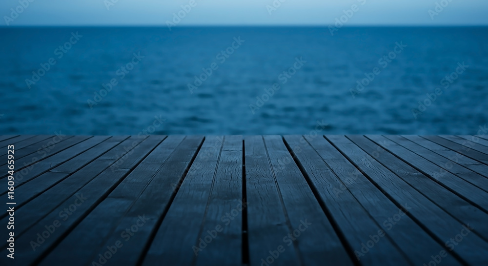 Serene view from a wooden deck over the deep blue ocean at dusk. A peaceful and moody landscape background with copy space. Serene view from a wooden deck over the deep blue ocean at dusk. A peaceful and moody landscape background with copy space.