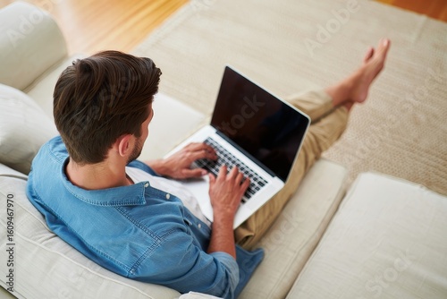 Man working on laptop at home on couch remote work lifestyle and home office concept