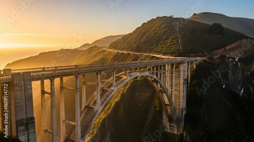 Scenic Bixby Creek Bridge vista at sunset with clear sky and cliffside, featuring golden hour lighting over the sea and the dramatic pacific coastal