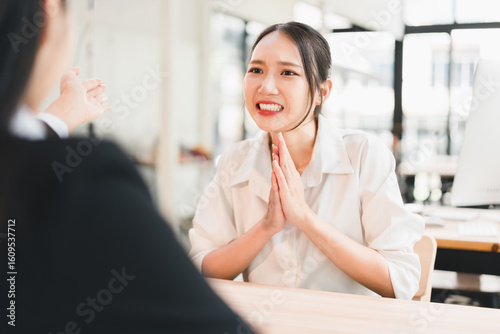 Obraz na plátně Young Asian woman in white shirt smiling and clasping hands together in gratitud