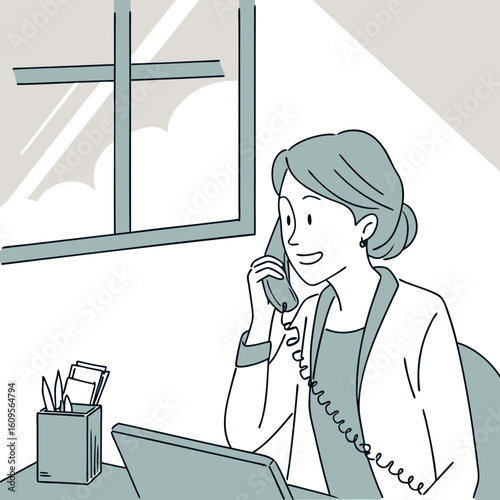Young woman talking on the phone while sitting at desk in office  