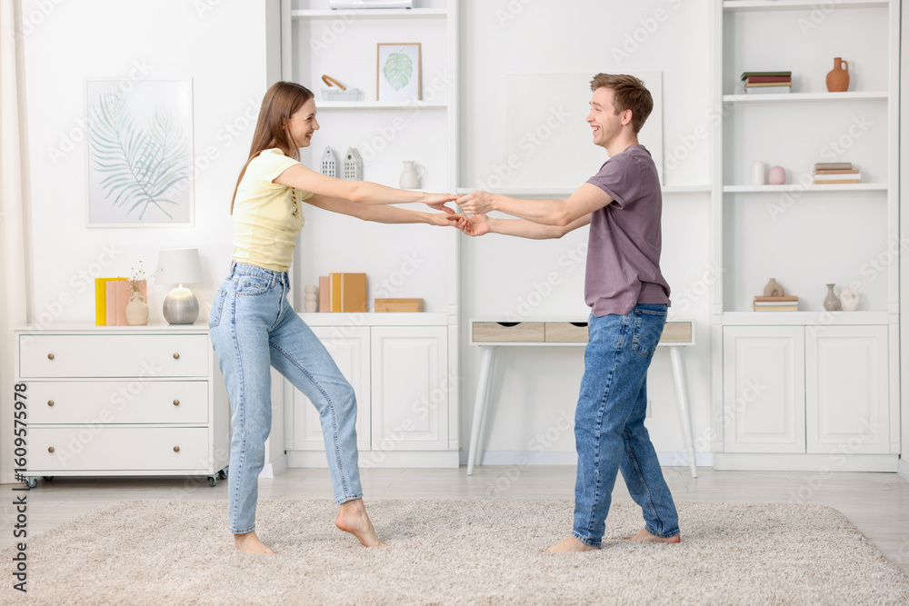 Fototapeta premium Happy young couple dancing together at home