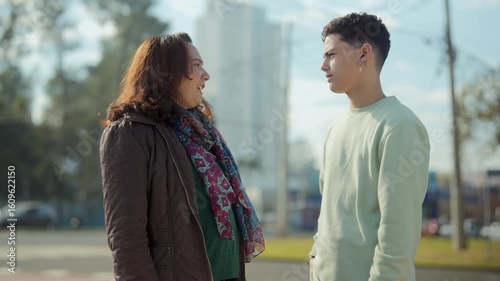 Mother and teenage son talking outdoors in the city