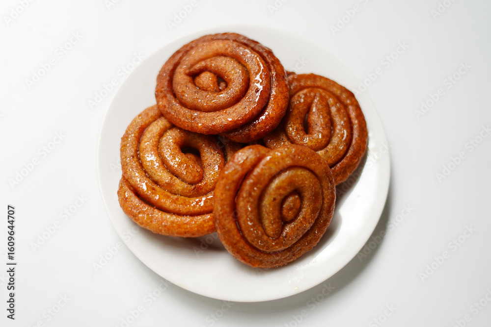 Fototapeta premium gold color Spiral Hard Candies in White Dish on Minimal White Backdrop